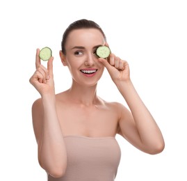 Beautiful woman covering eye with piece of cucumber on white background