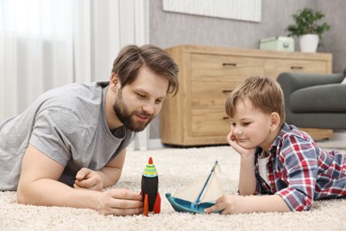 Photo of Dad and son playing toys together at home