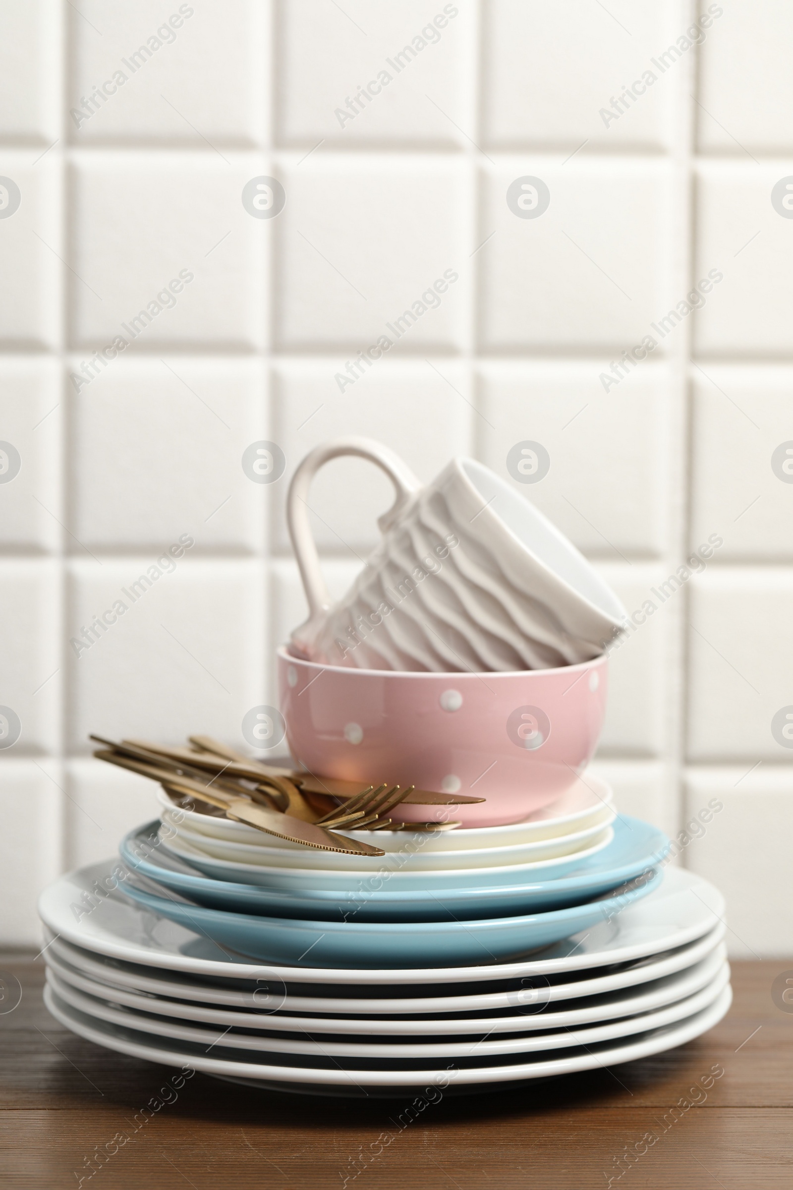 Photo of Beautiful ceramic dishware, cup and cutlery on wooden table