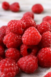 Photo of Heap of tasty ripe raspberries on table, closeup