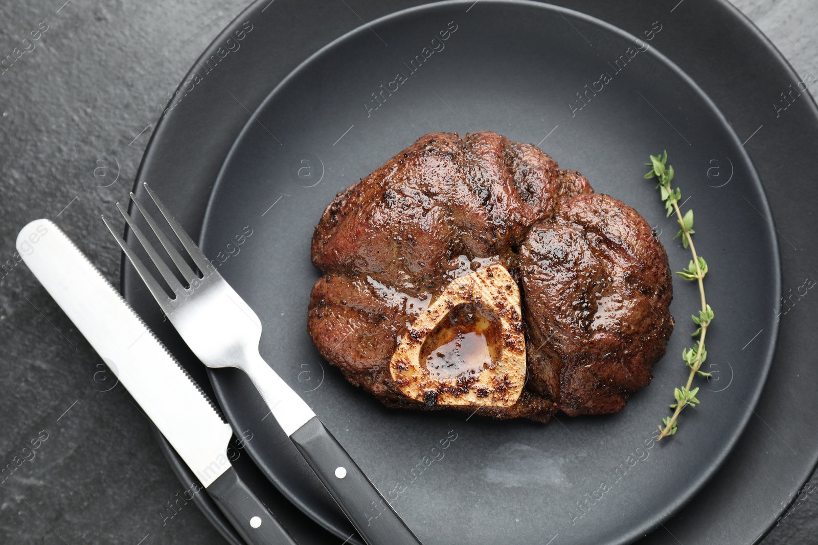 Photo of Tasty grilled beef meat served on black table, top view