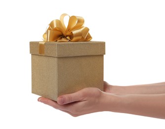 Photo of Woman holding golden gift box on white background, closeup