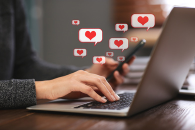 Image of Young woman using laptop at table indoors, closeup. Social media