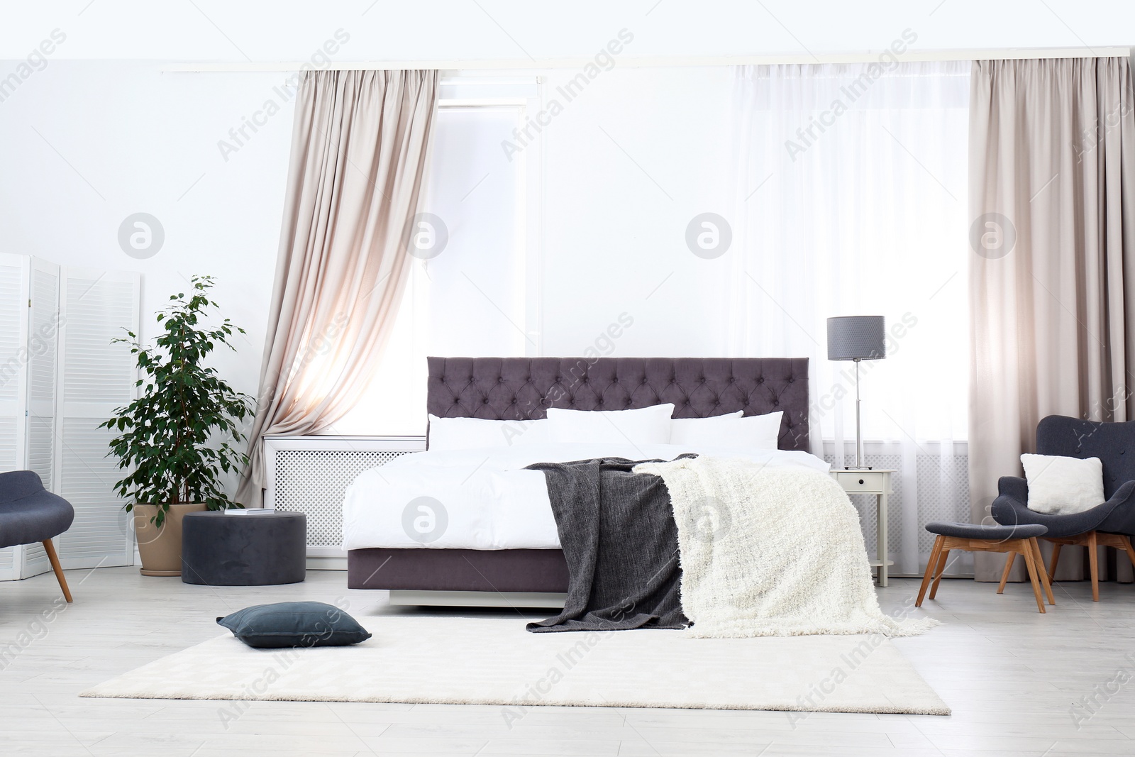 Photo of Large comfortable bed in stylish room. Apartment interior design