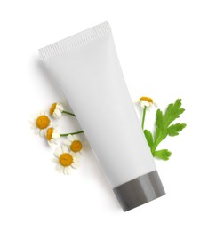 Blank tube of body cream with camomile flowers on white background, top view