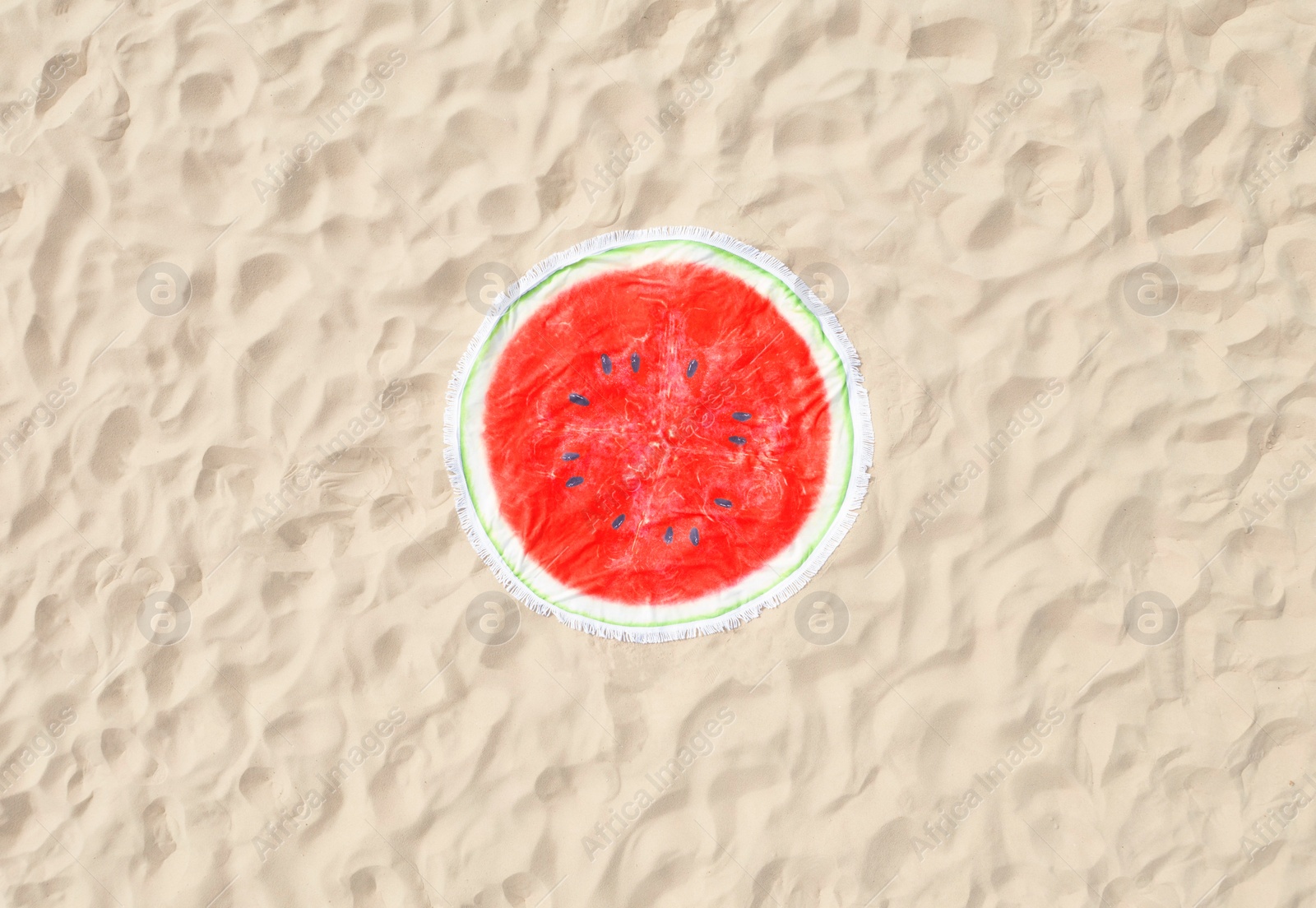 Image of Round watermelon beach towel on sand, aerial view