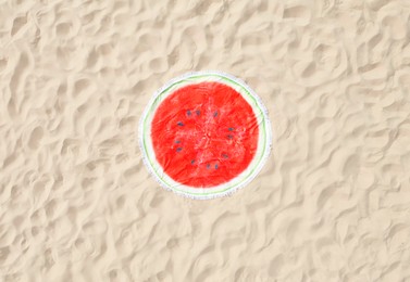 Round watermelon beach towel on sand, aerial view