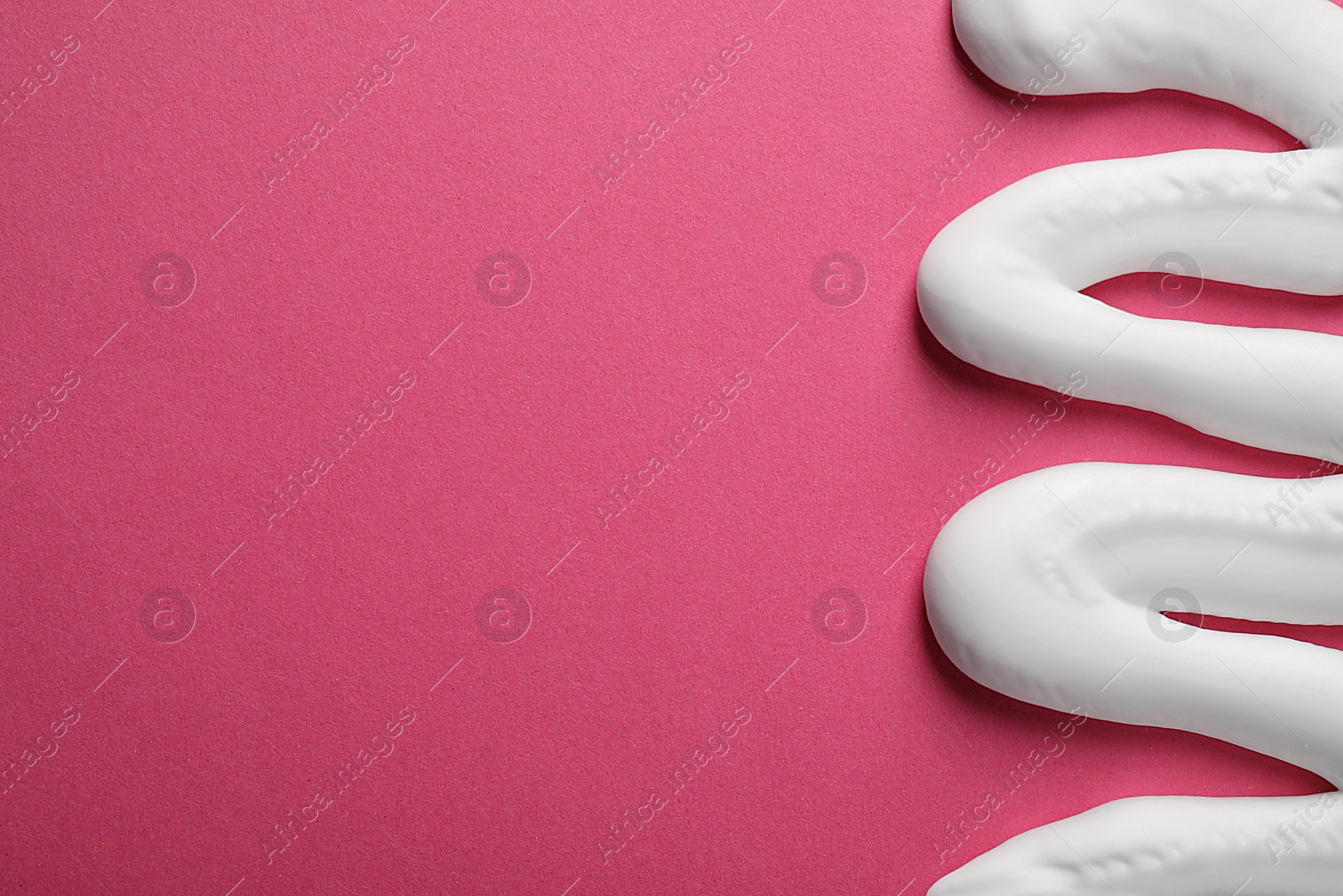 Photo of Sample of shaving foam on pink background, top view. Space for text