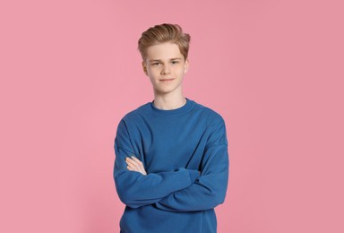 Portrait of teenage boy on pink background