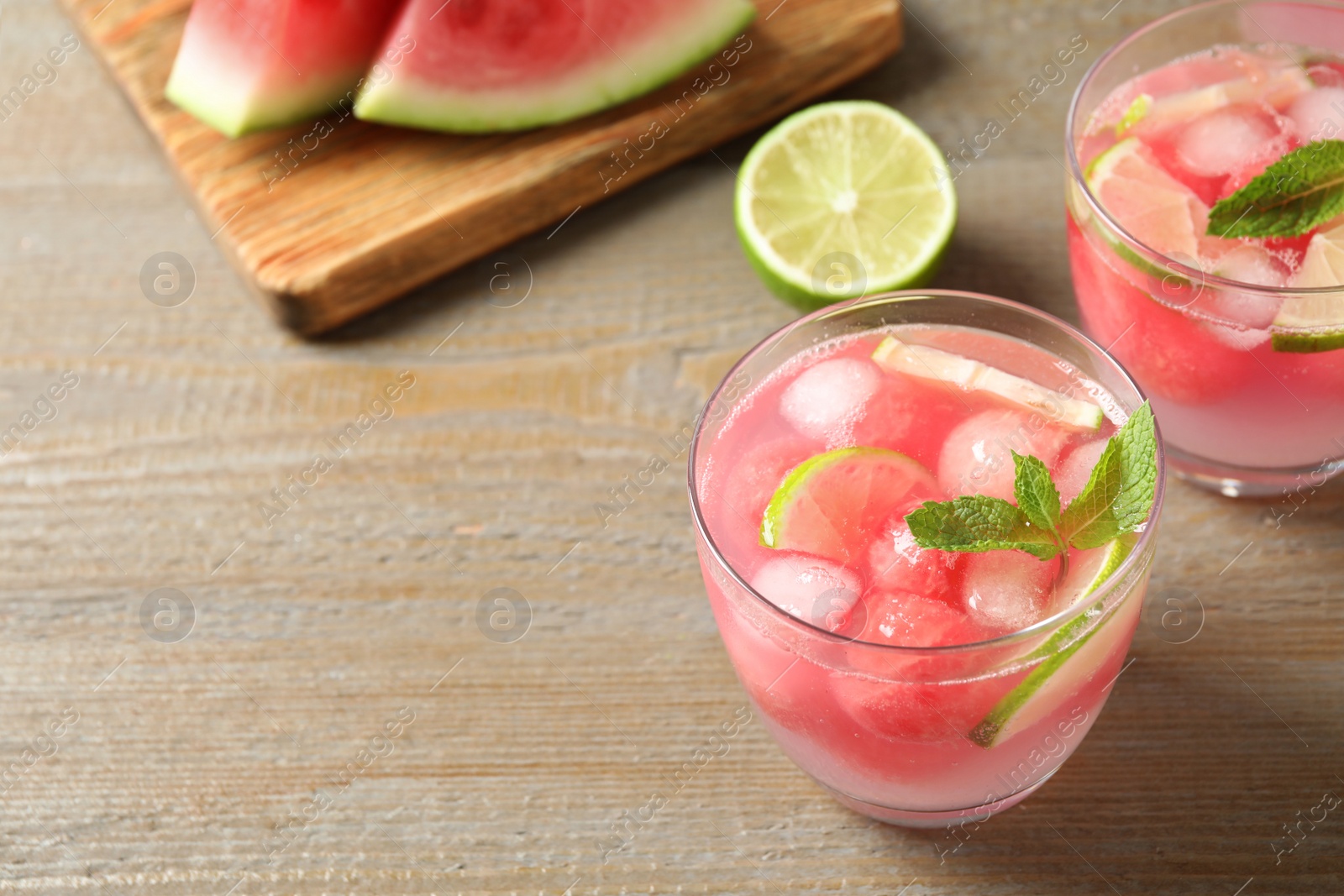 Photo of Tasty refreshing watermelon drink on wooden table. Space for text