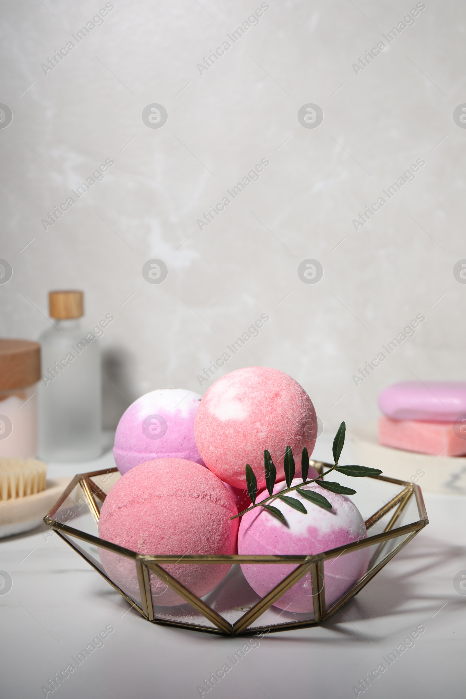 Photo of Beautiful aromatic bath bombs and green twig on white table, space for text