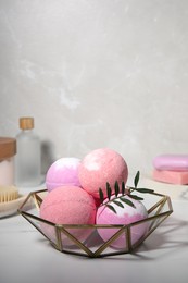 Beautiful aromatic bath bombs and green twig on white table, space for text