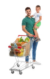 Father and son with full shopping cart on white background