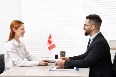 Immigration to Canada. Smiling woman having interview with embassy worker in office