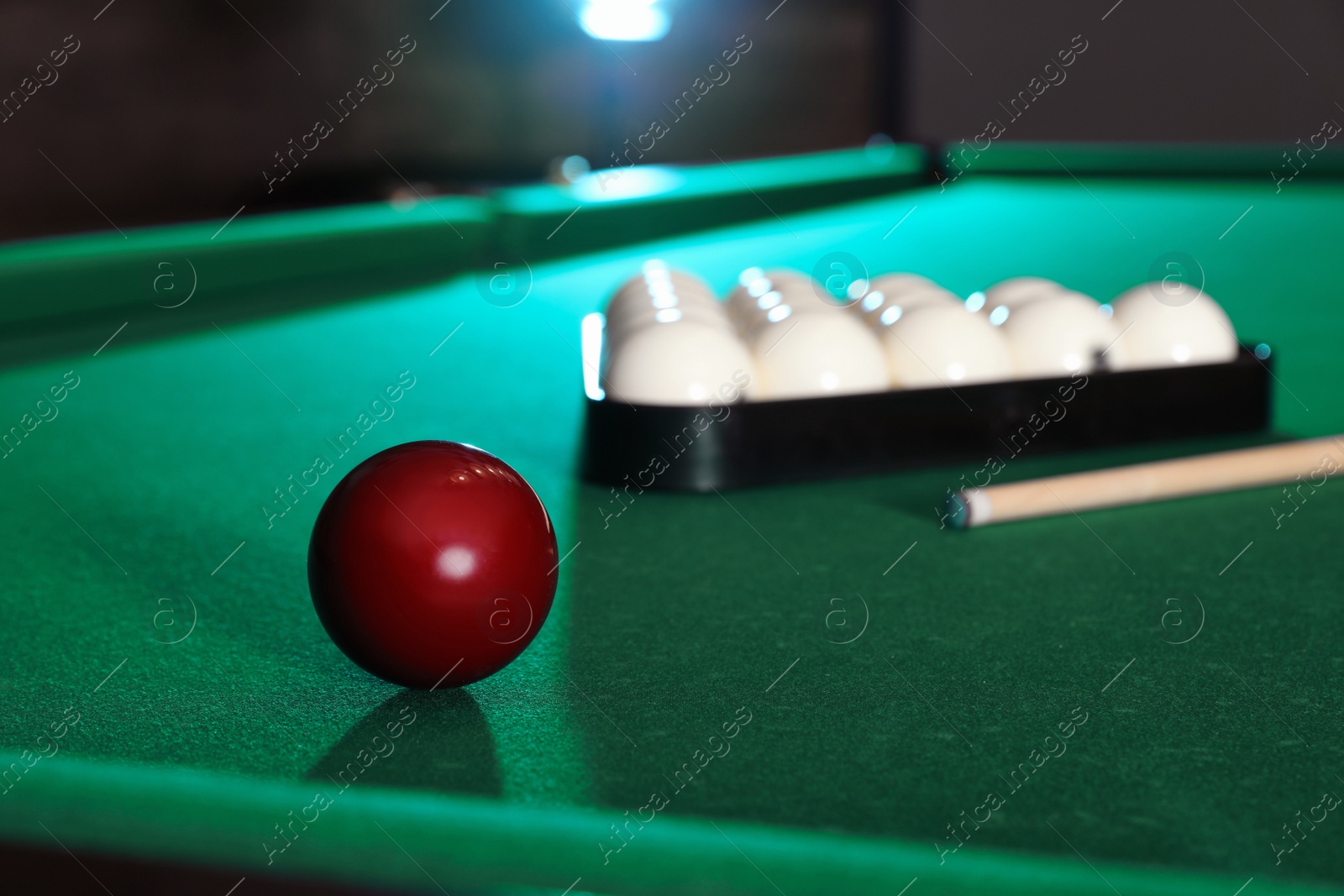 Photo of Billiard balls, triangle rack and cue on table. Space for text