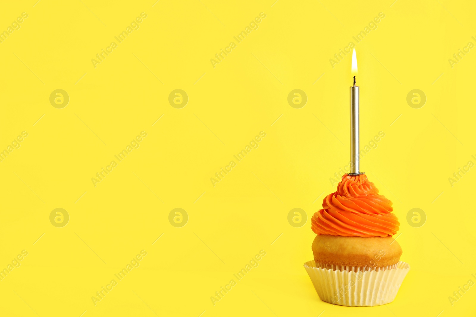 Photo of Birthday cupcake with candle on yellow background, space for text