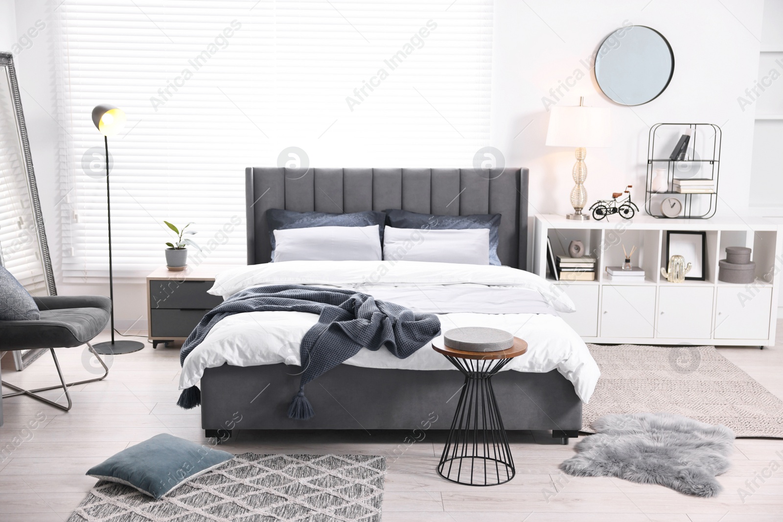 Photo of Bright plaid on bed in stylish bedroom. Interior design