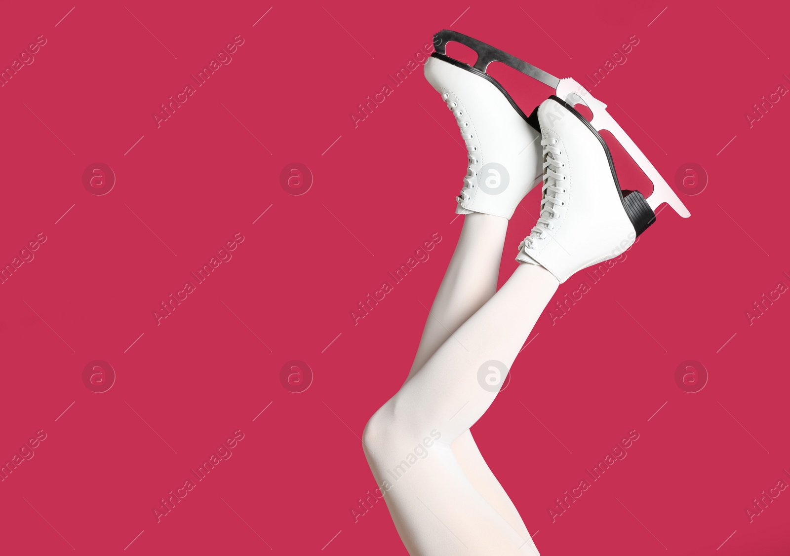 Photo of Woman in elegant white ice skates on pink background, closeup of legs. Space for text