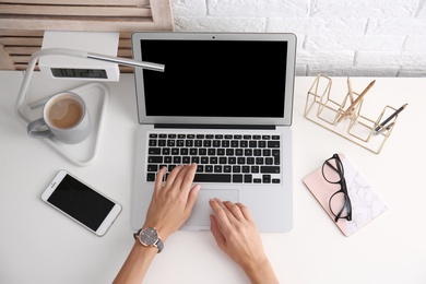 Photo of Woman using with laptop at table, top view. Mockup for design