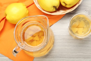 Delicious quince drink and fresh fruits on wooden table, top view