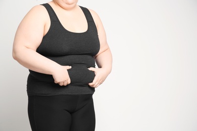 Overweight woman on light background