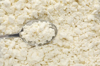 Photo of Delicious fresh cottage cheese and spoon as background, top view