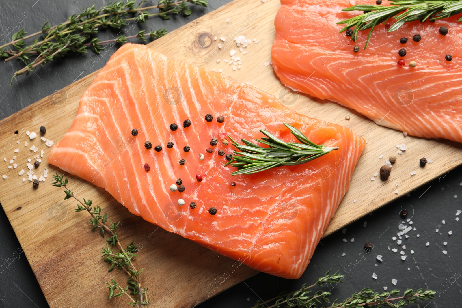 Photo of Fresh raw salmon and ingredients for marinade on black table, flat lay