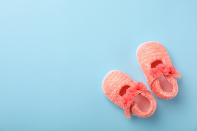 Pair of cute baby sandals on color background, top view