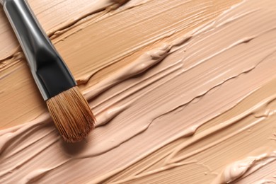 Photo of Samples of skin foundation and makeup brush, top view