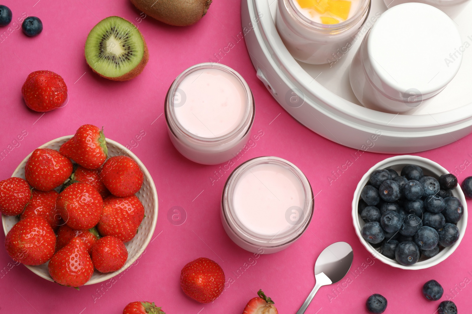 Photo of Yogurt maker with jars and different fruits on pink background, flat lay