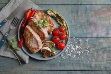 Photo of Delicious grilled meat and vegetables served on wooden table, flat lay. Space for text