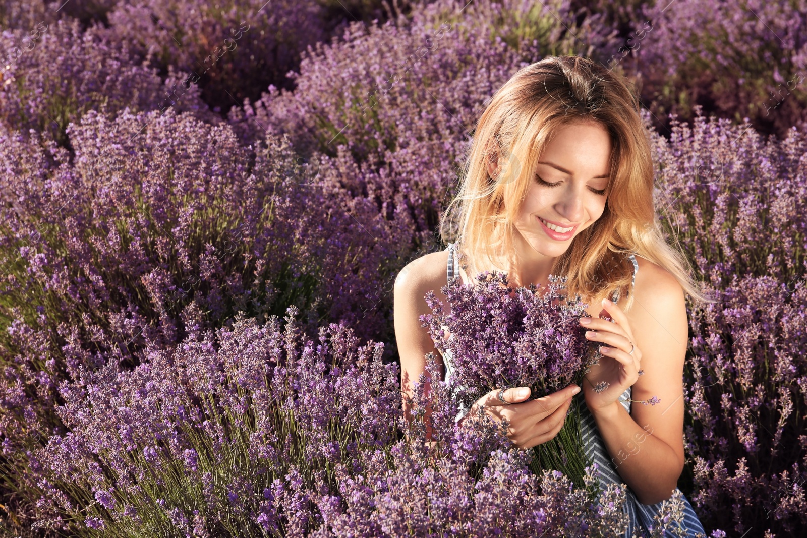 Photo of Young woman with bouquet in lavender field