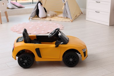 Photo of Yellow car in room at home. Child's toy