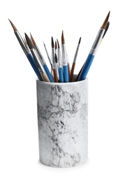 Holder with different paint brushes on white background