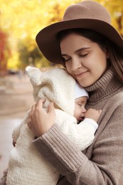 Happy mother with her sleeping daughter on city street