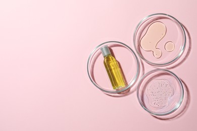 Many Petri dishes and cosmetic products on pink background, flat lay. Space for text