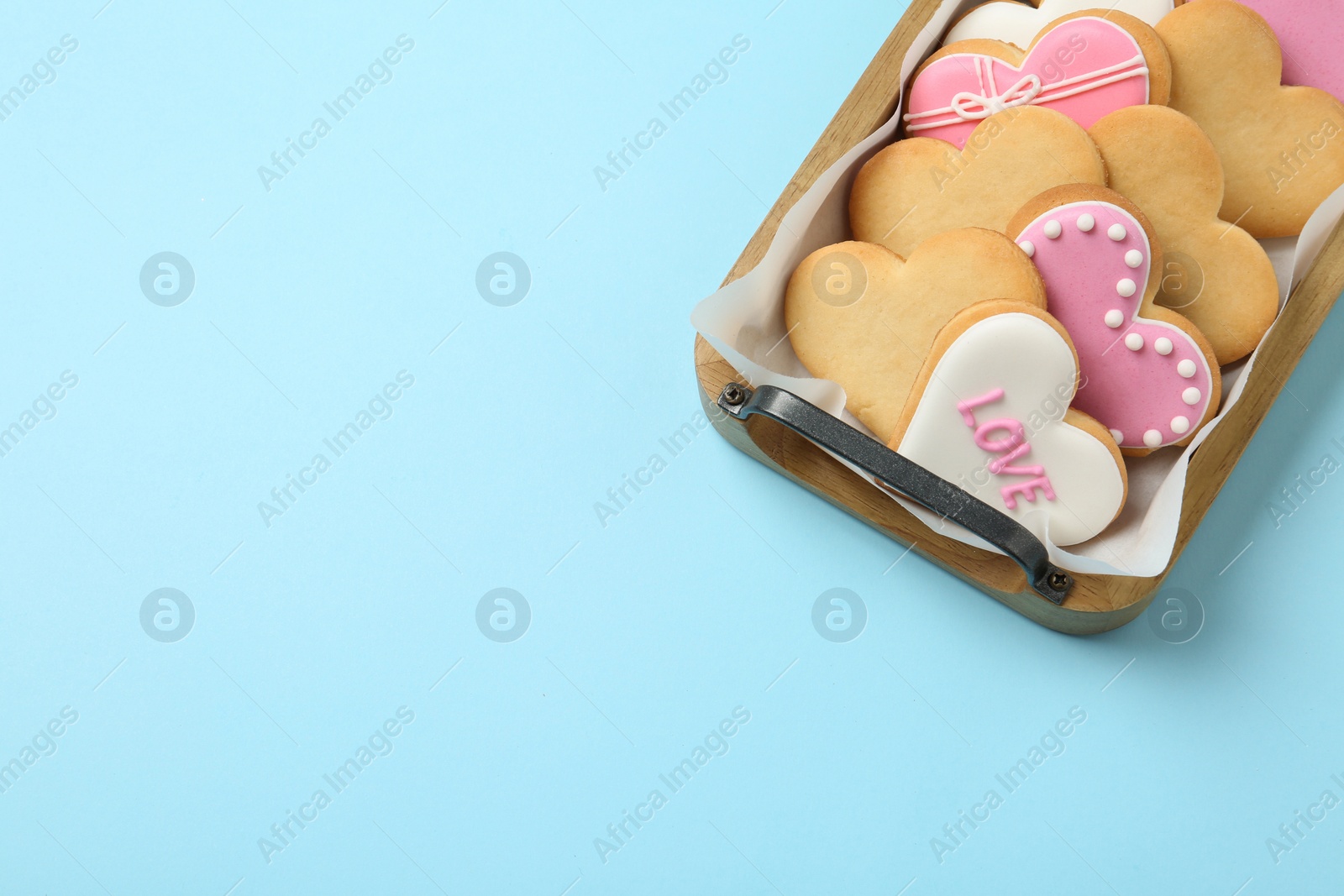 Photo of Tray with decorated heart shaped cookies and space for text on color background, top view