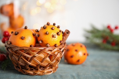 Pomander balls made of fresh tangerines and cloves on wooden table, closeup. Space for text