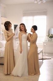 Photo of Happy bride and bridesmaids in room at home. Wedding day