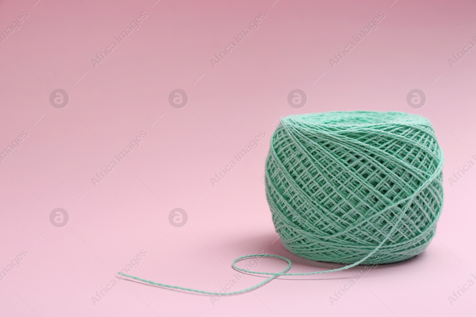 Photo of Clew of knitting threads on color background, space for text. Sewing stuff