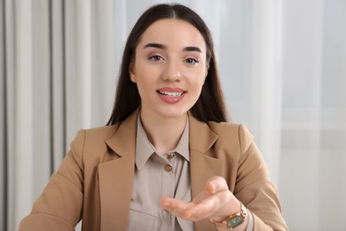 Photo of Beautiful young woman having online video call at home, view from camera