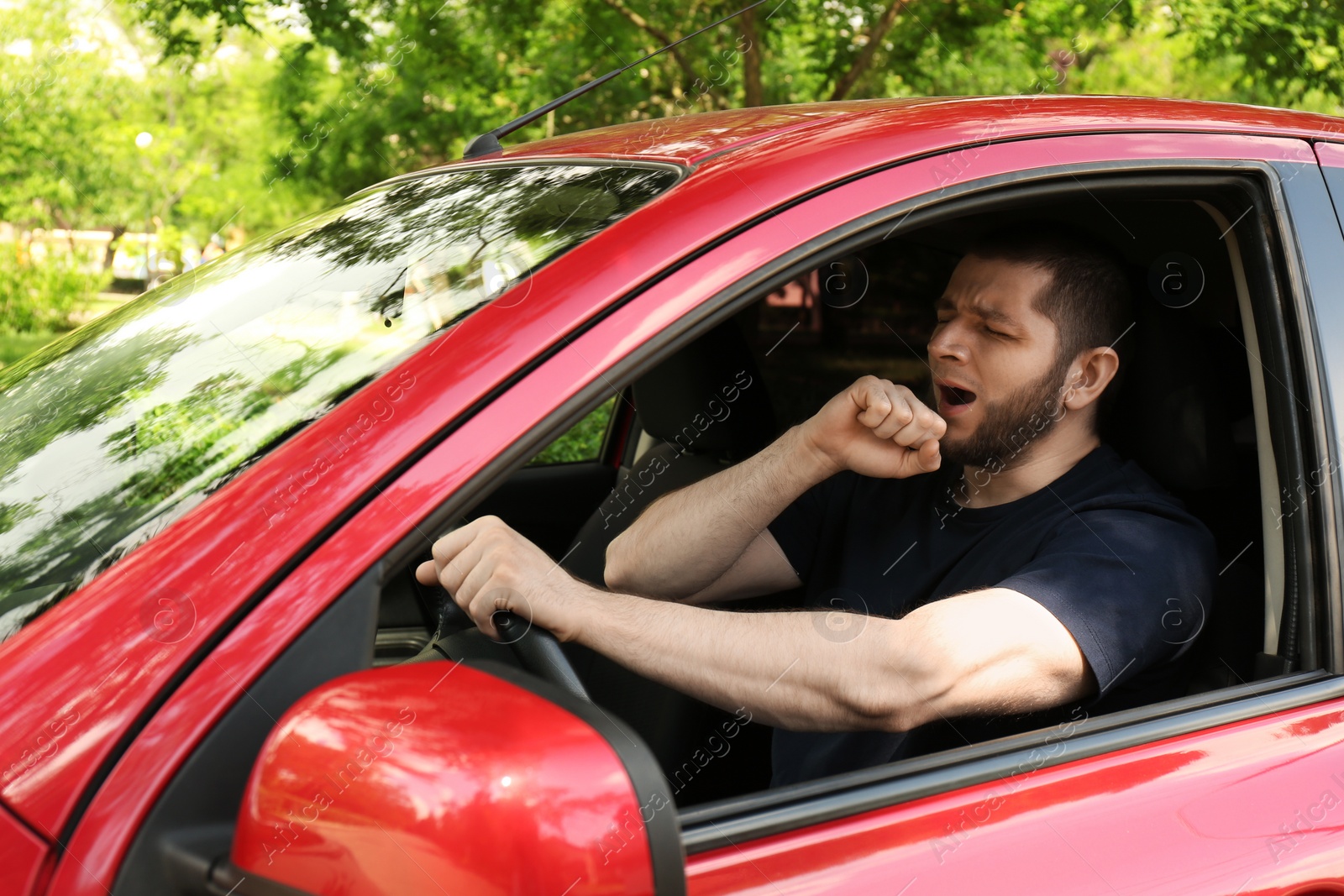 Photo of Tired man yawning while driving his modern car