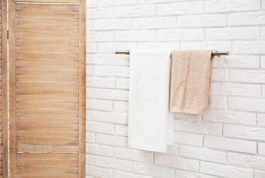 Photo of Fresh clean towels on hanger in bathroom