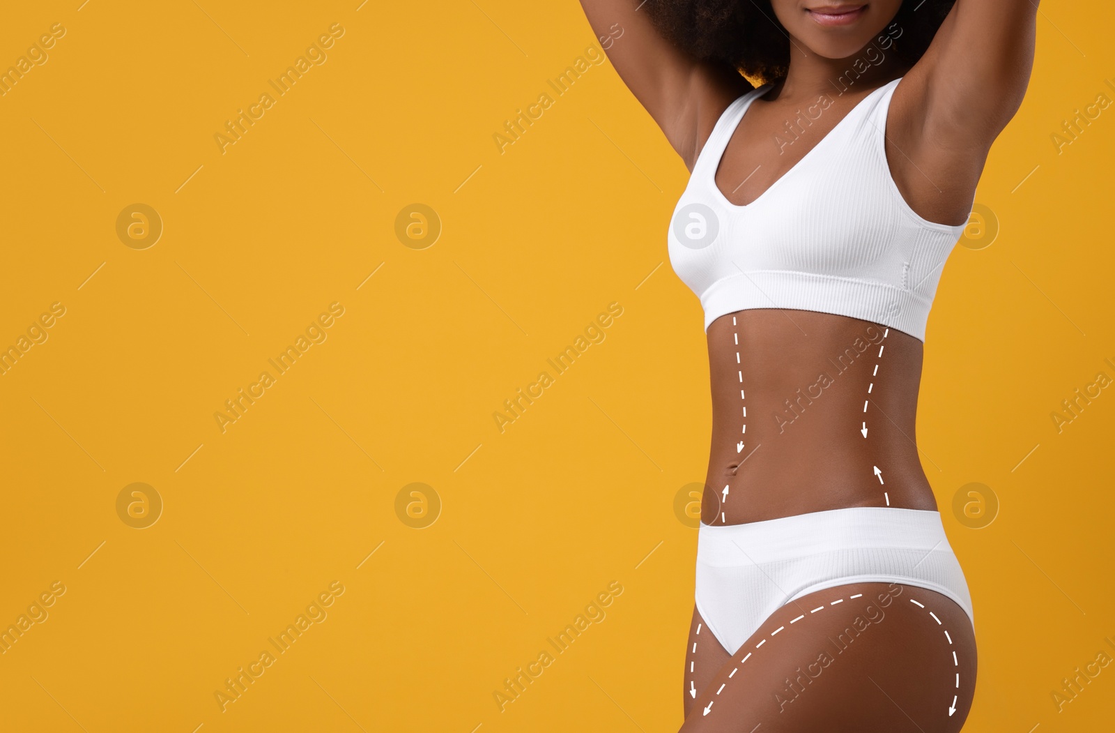 Image of Woman showing her beautiful figure on orange background, closeup. Space for text. Cosmetic treatment lines on her body