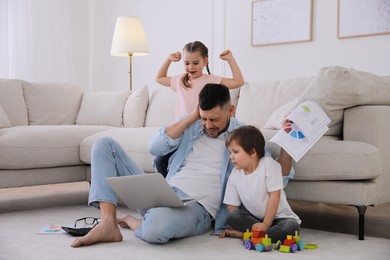 Photo of Overwhelmed man combining parenting and work at home