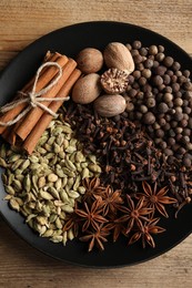 Photo of Different spices and nuts on wooden table, top view