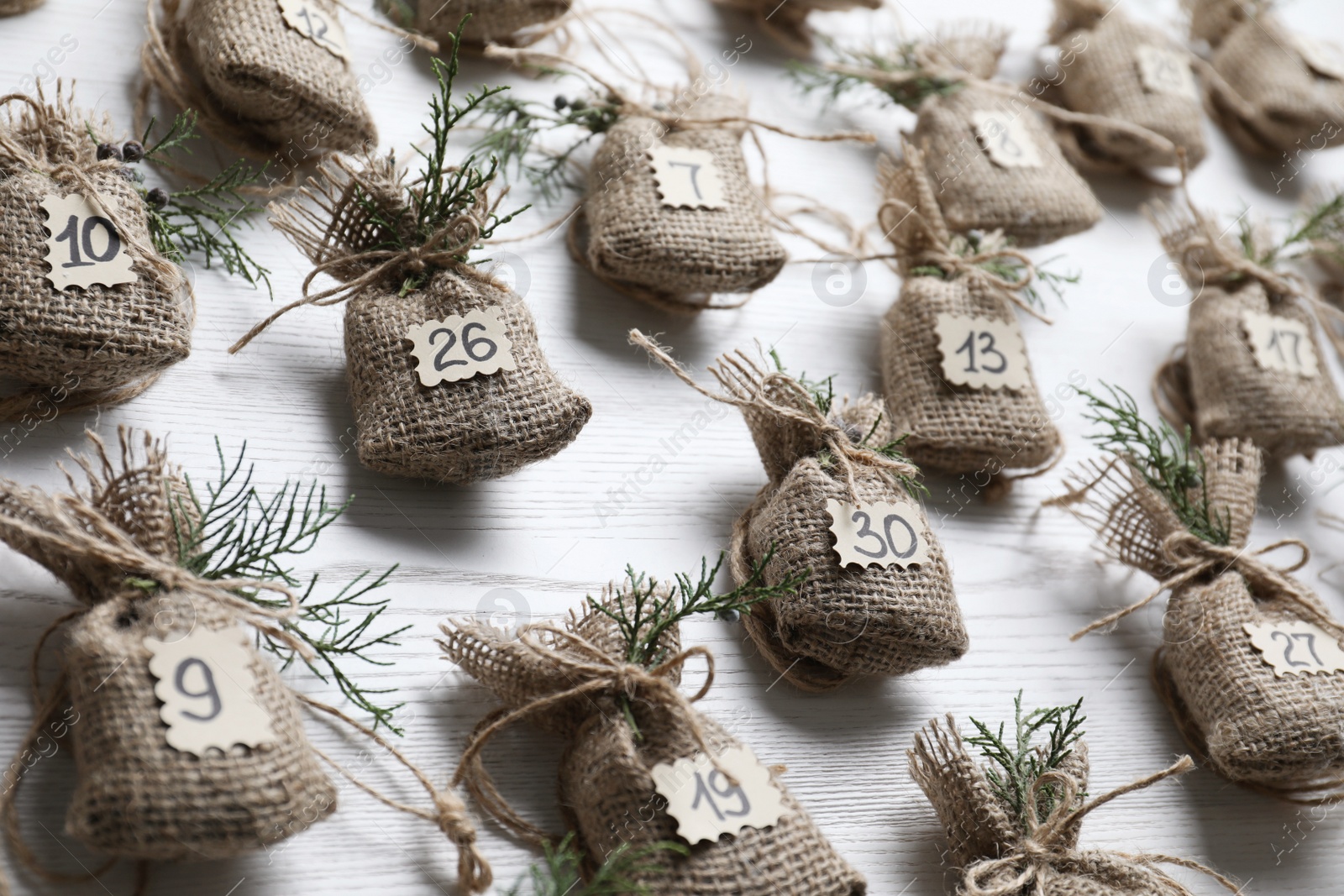 Photo of New Year advent calendar with gifts on white wooden background