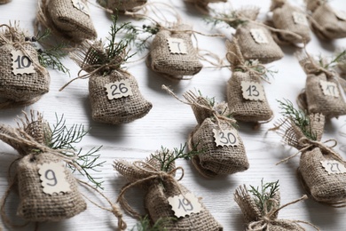 New Year advent calendar with gifts on white wooden background