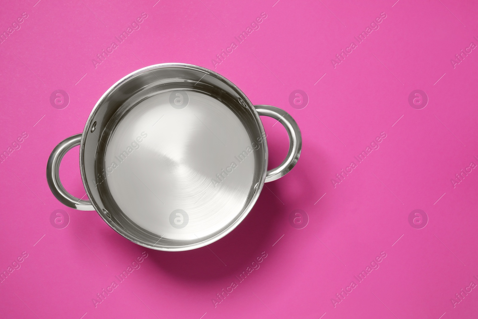 Photo of Empty steel pot on dark pink background, top view. Space for text