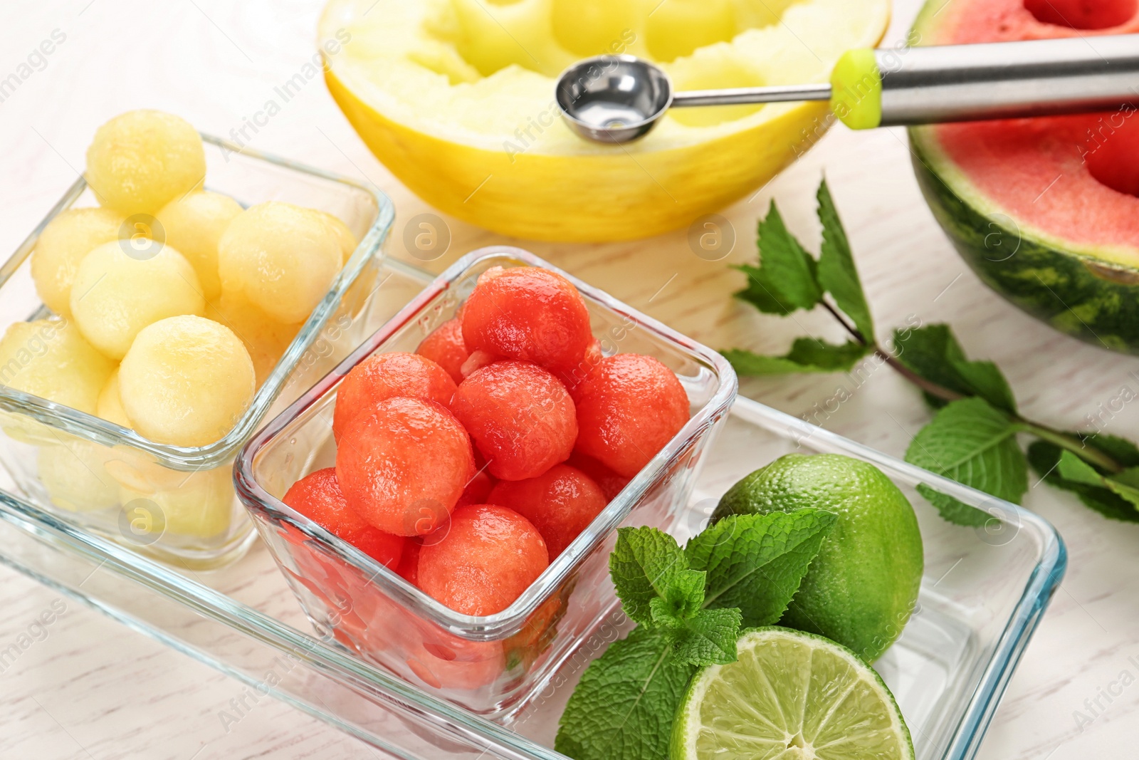 Photo of Melon and watermelon balls with lime served on white wooden table